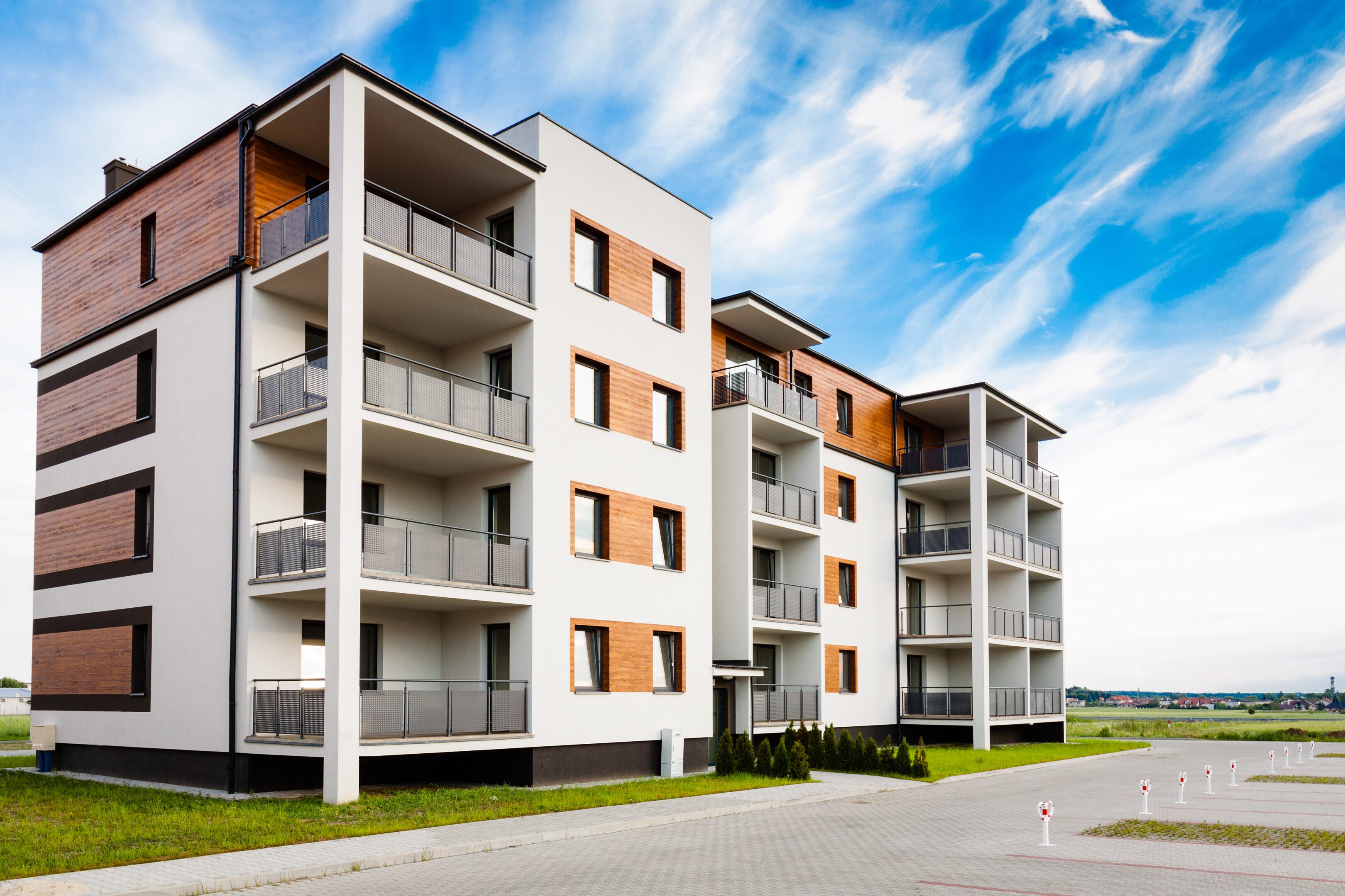 New multi-family block with balconies and bright facade decorated with wood paneling.